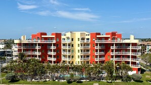 A multi-story hotel with balconies, a swimming pool, and a view of the sea. - Vitamin SEA Condo 7️⃣2️⃣7️⃣2️⃣5️⃣1️⃣8️⃣6️⃣5️⃣9️⃣ (Treasure Island)