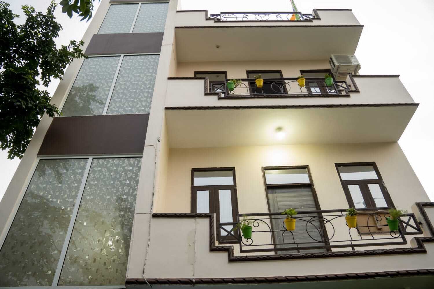 A multi-story building with balconies, large windows, and outdoor lighting.
