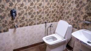 Casa de banho com sanita, bidé e lavatório.