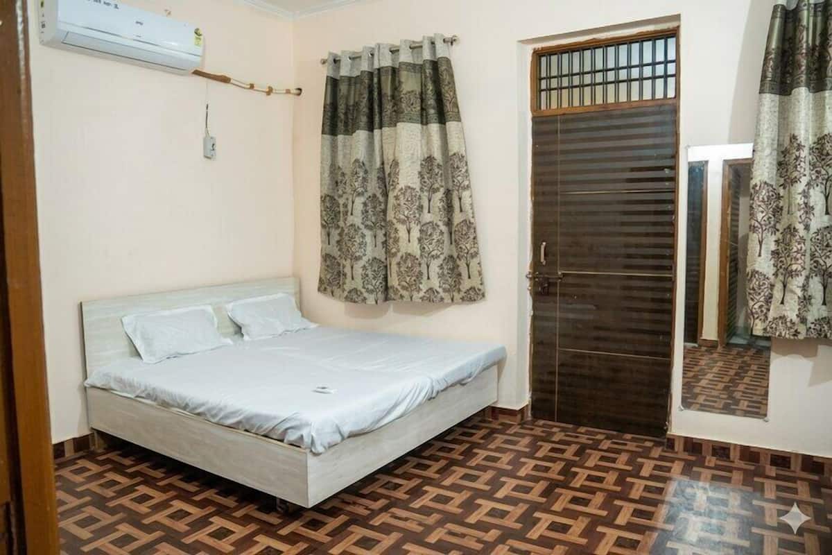 Un dormitorio con cama, cortinas, una puerta y piso estampado.