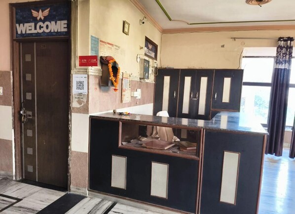 A reception area with a 'WELCOME' sign, a counter with a computer, and a door marked '209'. - Hotel Bombay Central Agra (Agra)