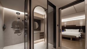 A modern bathroom with a walk-in shower, a vanity with a mirror, and a bedside table with a lamp. - IntercityHotel Shenzhen Futian Huanggang (Shenzhen)