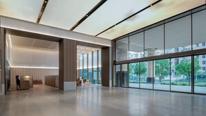 A spacious lobby with a modern design, featuring a large glass wall offering a view of the cityscape and greenery. - IntercityHotel Shenzhen Futian Huanggang (Shenzhen)