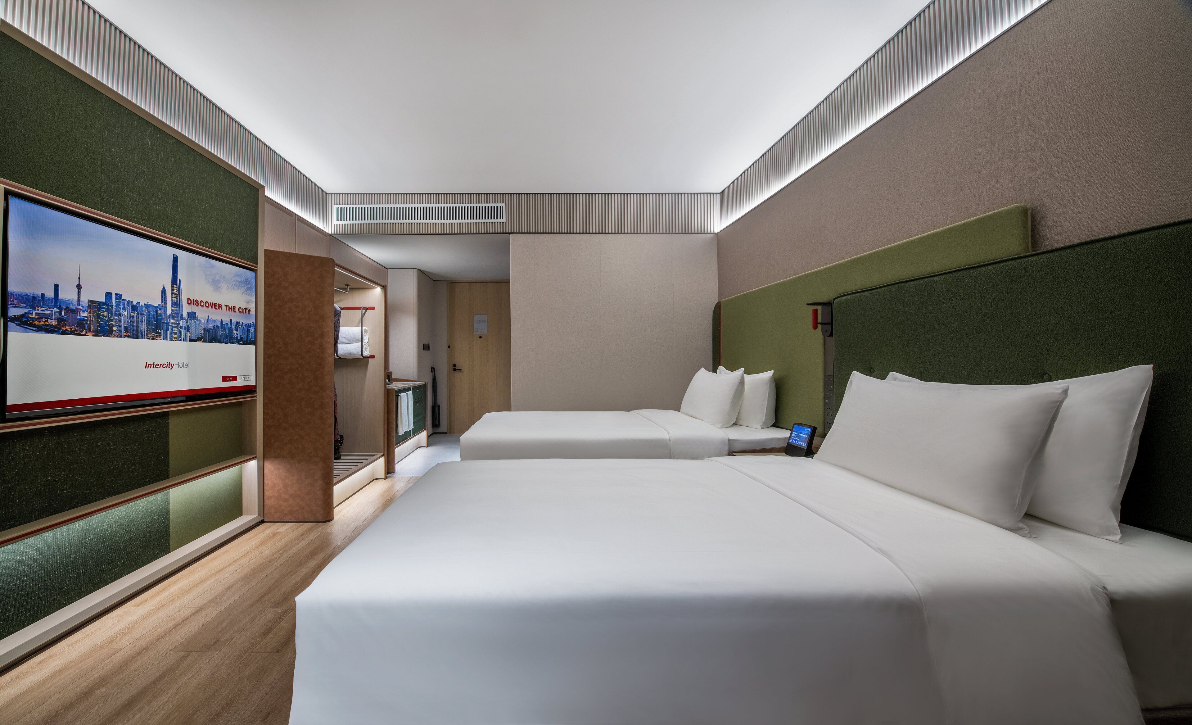 Habitación de hotel con dos camas, un televisor y vistas del horizonte urbano.