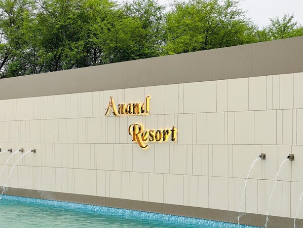 Señal para el 'Anand Resort', con piscina y fuentes de agua.
