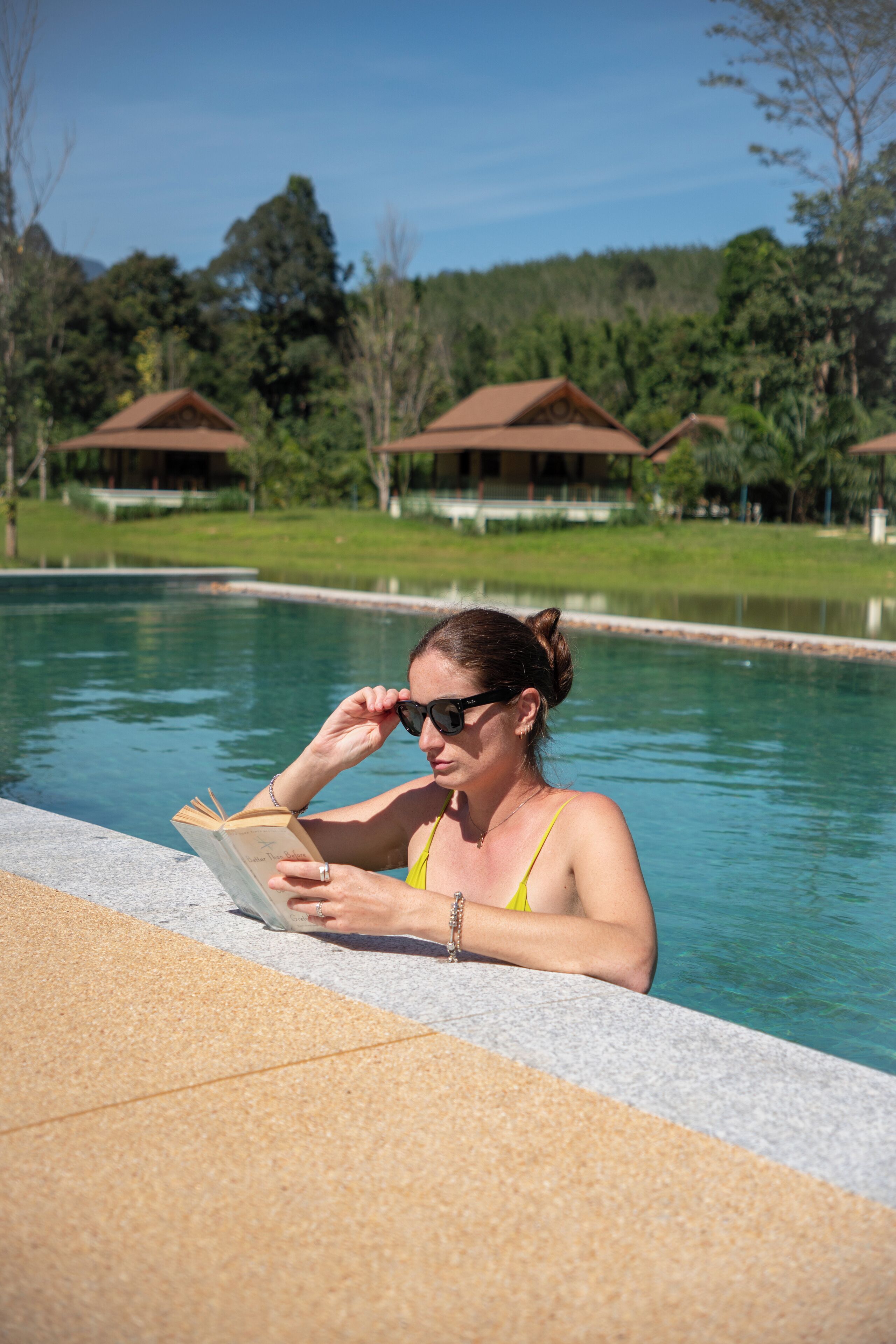Una piscina al aire libre, sombrillas, sillones reclinables de piscina