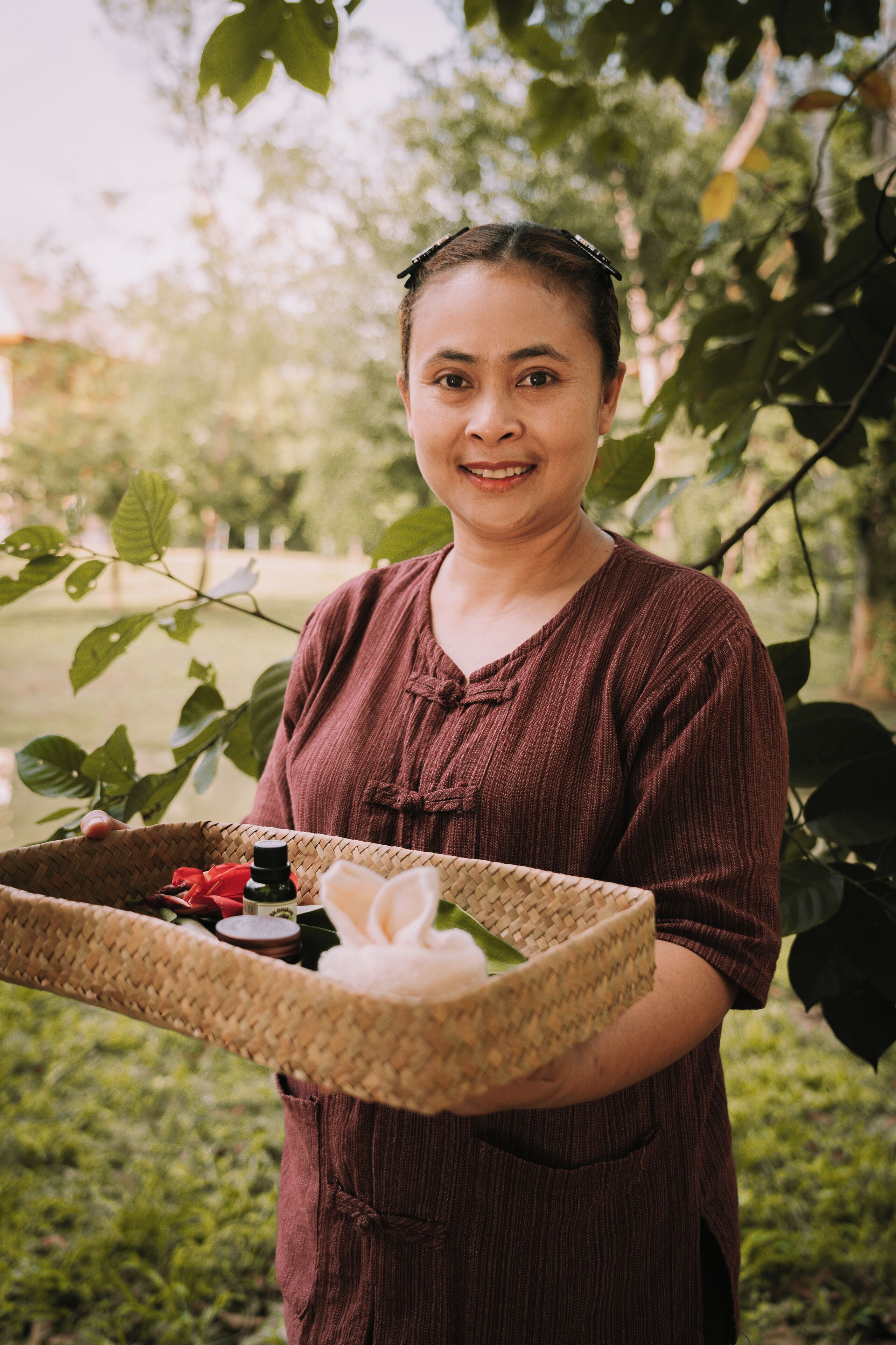 A person holding a woven basket with items.