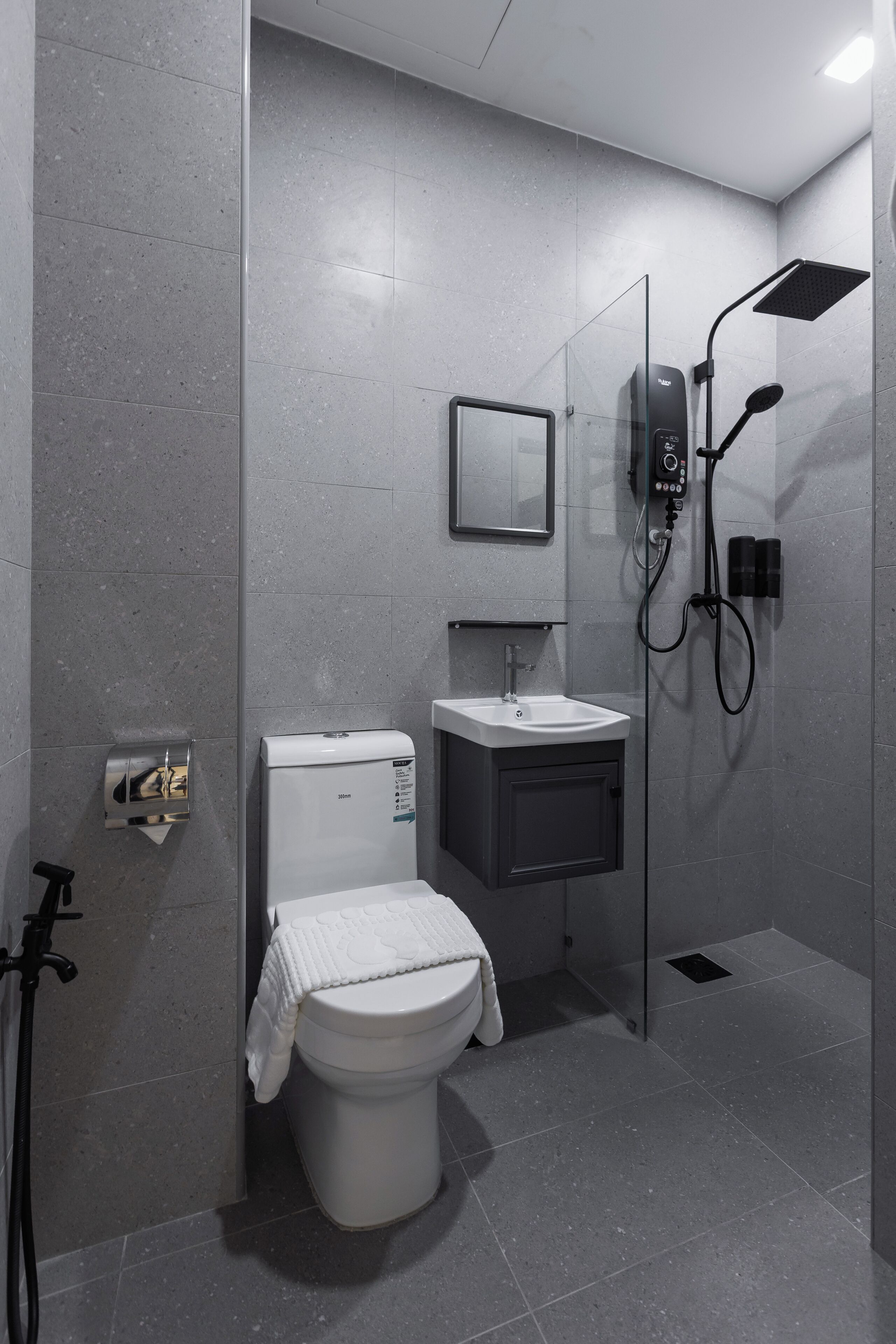 Ein modernes Badezimmer mit Toilette, Waschbecken und Dusche.