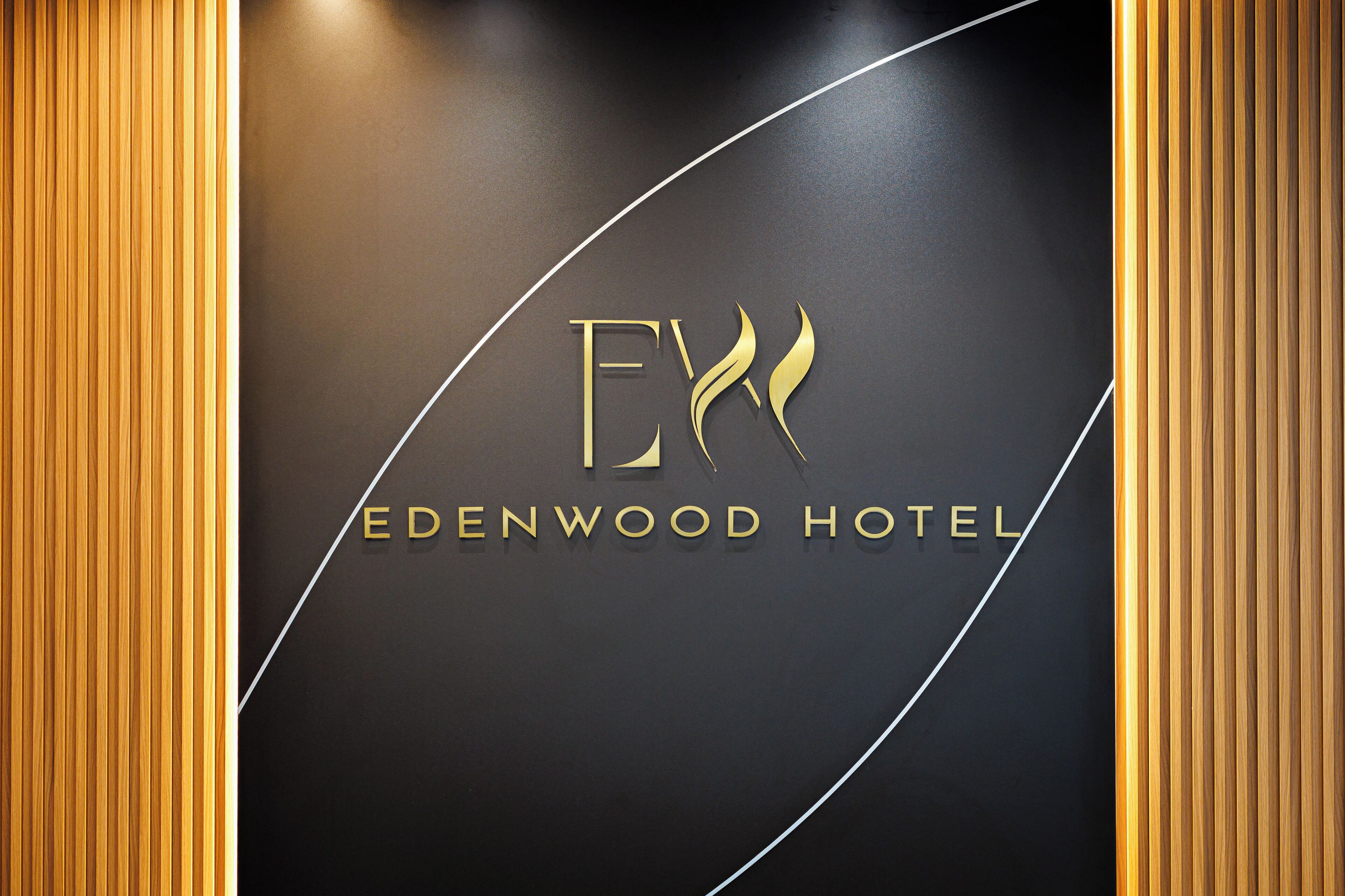 A logo with the text "EDENWOOD HOTEL" and stylized 'E' and 'X'.