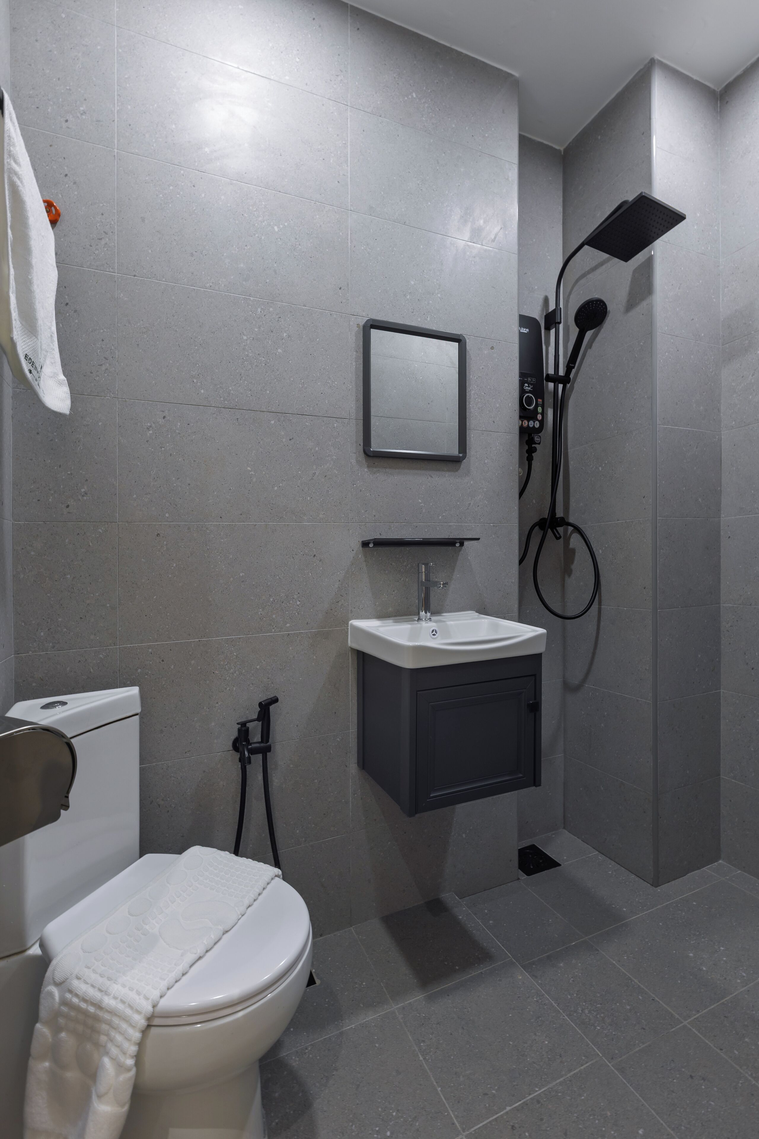 A modern bathroom with a toilet, sink, and shower.