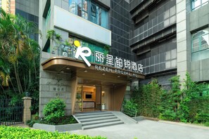 A hotel entrance with a modern design, featuring a prominent logo and signage. - Licheng Platinum Hotel (Guangzhou)