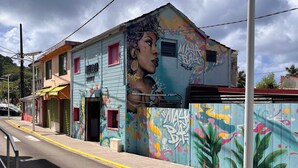 A street view with a building featuring a colorful mural.