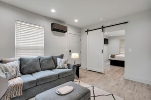 Una sala de estar moderna con un sofá gris, una mesita auxiliar y una bandeja con un libro.