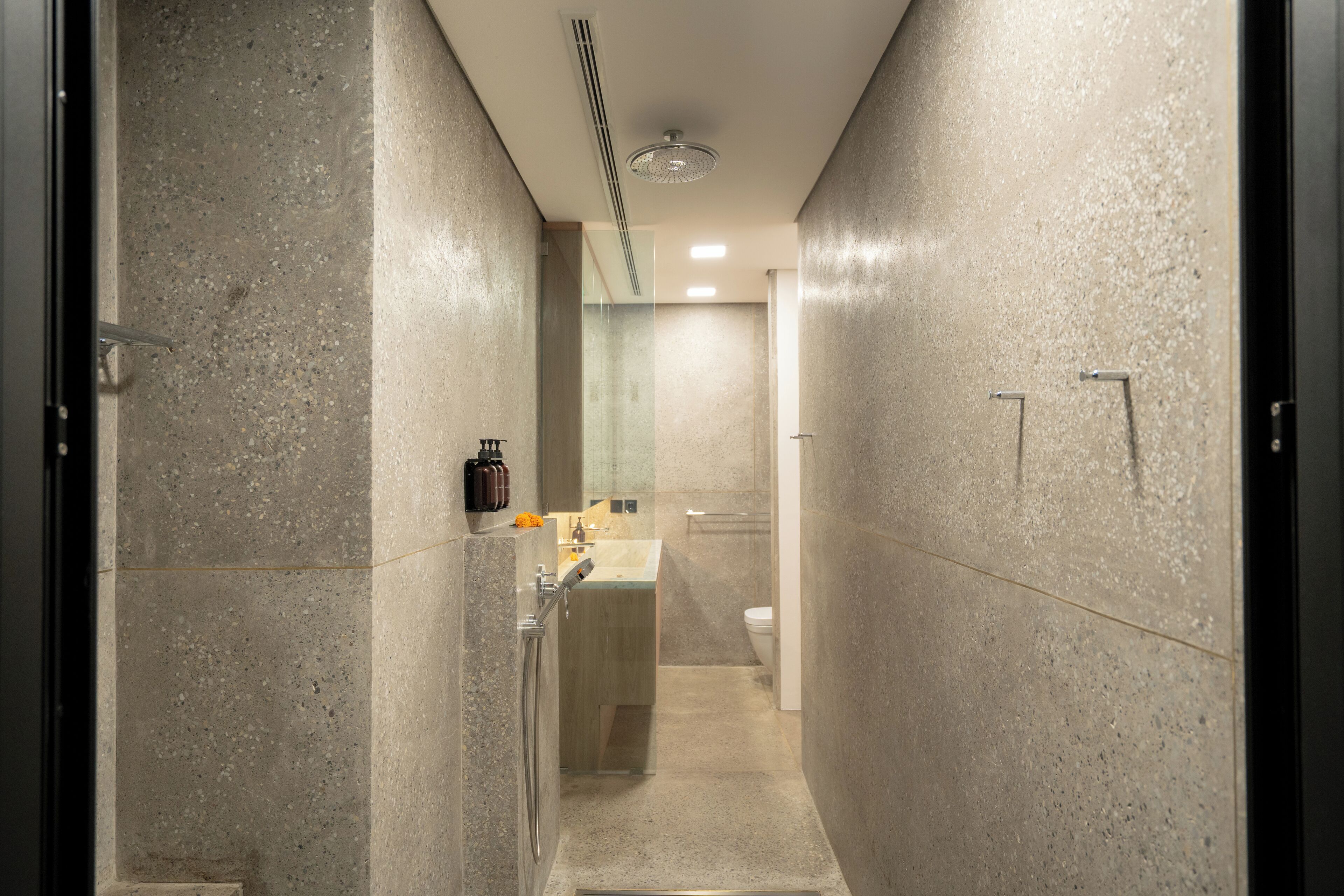 Een moderne badkamer met douche, wastafel en toilet.