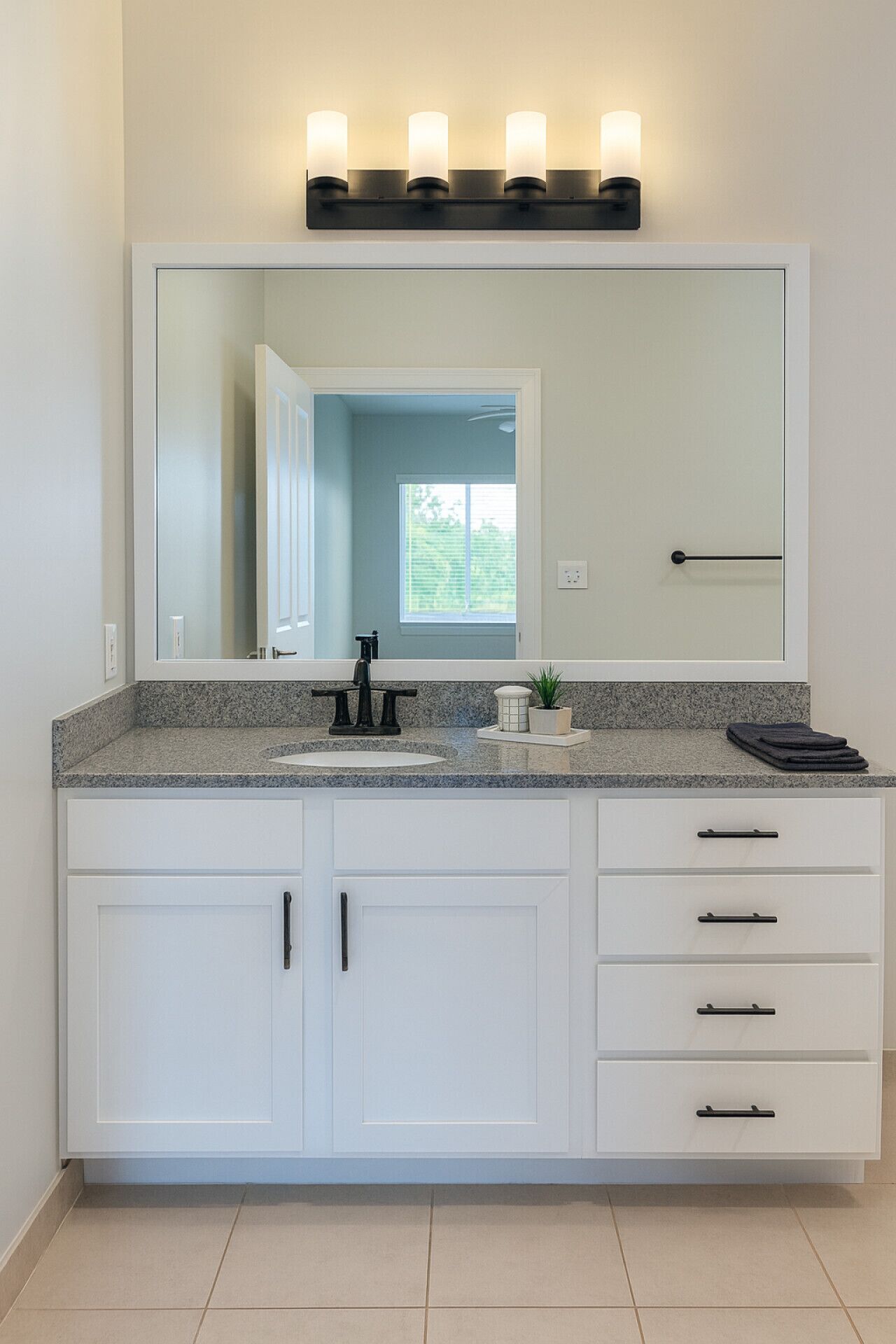 Une salle de bain avec un grand miroir, un lavabo et un meuble-lavabo doté de tiroirs.