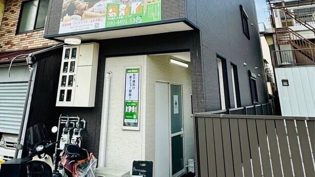 A modern building with a grey facade, a visible storefront, and a sign for a beauty salon. - GUEST HOUSE TEN (Osaka)
