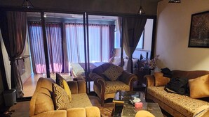 A living room with two sofas, a coffee table, and a patterned rug. - HARD ROCK HUNZA (Karimabad)