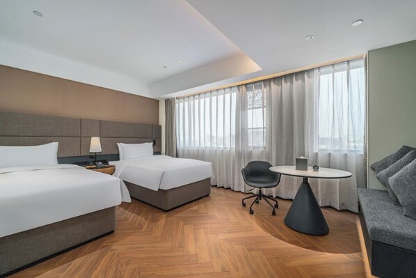 A hotel room with two beds, a desk, a chair, and a sofa. - IntercityHotel Hangzhou Xixi Huanglong (Hangzhou)