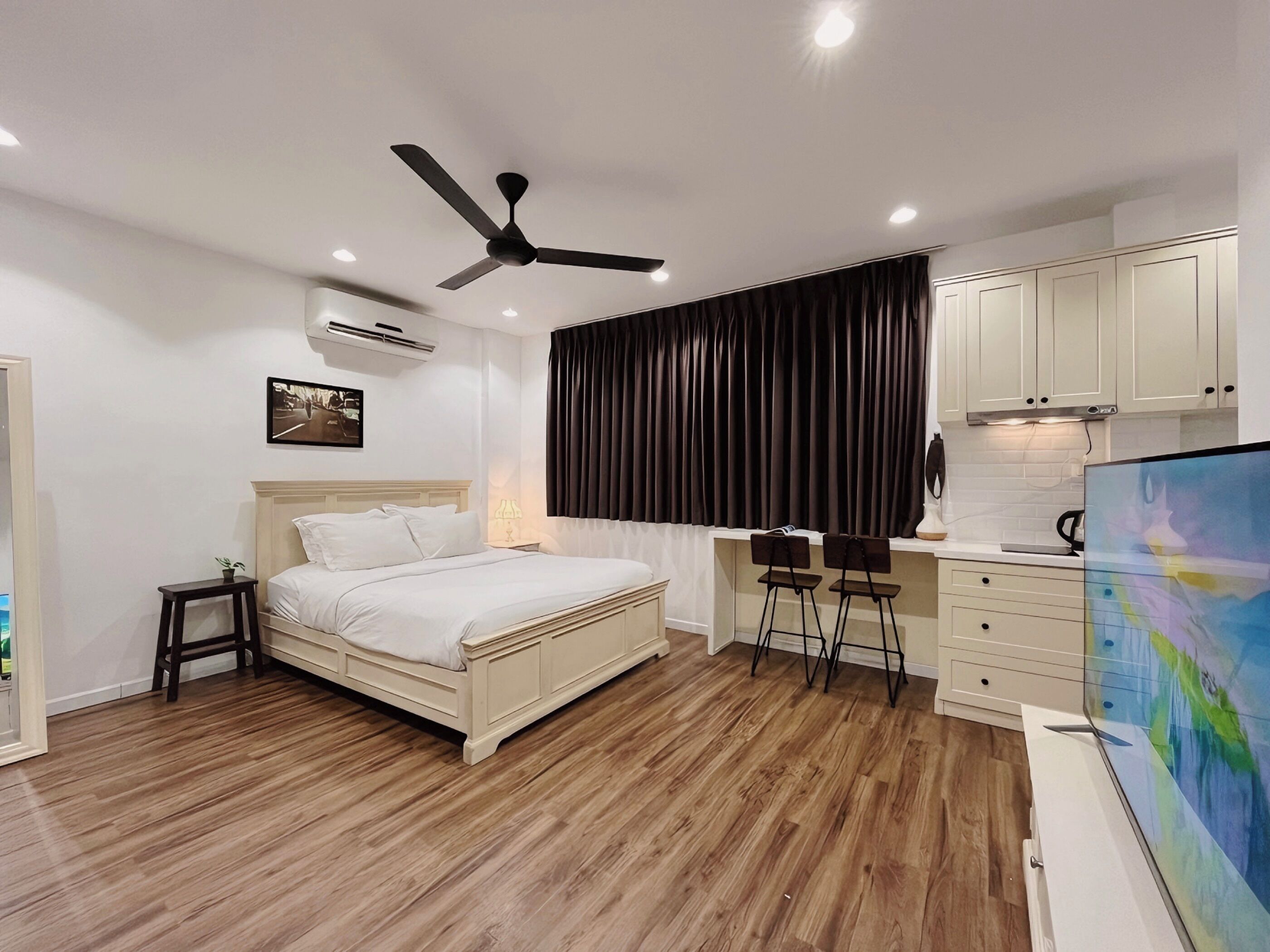 A bedroom with a bed, a desk, a chair, and a TV.