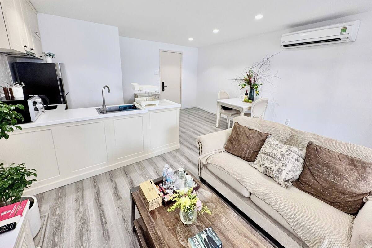 A modern living space with a kitchenette, a dining area, and a sofa.