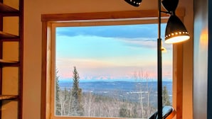 Ein Zimmer mit großem Fenster und Blick auf die Berge.
