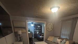 A compact living space with a sofa, a coffee table, a small cabinet, and a dining area visible through an open door. - Comfortable 2BR Retreat in Ruston Perfect for Game Days” (Ruston)