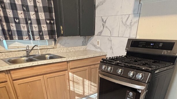 A kitchen with a stainless steel stove, wooden cabinets, and a marble countertop. - Comfortable 2BR Retreat in Ruston Perfect for Game Days” (Ruston)