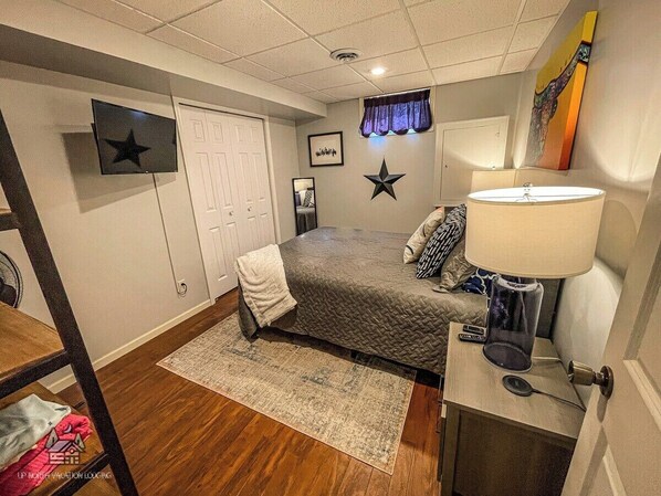 A bedroom with a bed, bedside table, lamp, and a star decoration on the wall. - Sunrise Pines Escape, Butternut Lake w/Hot Tub (Butternut)