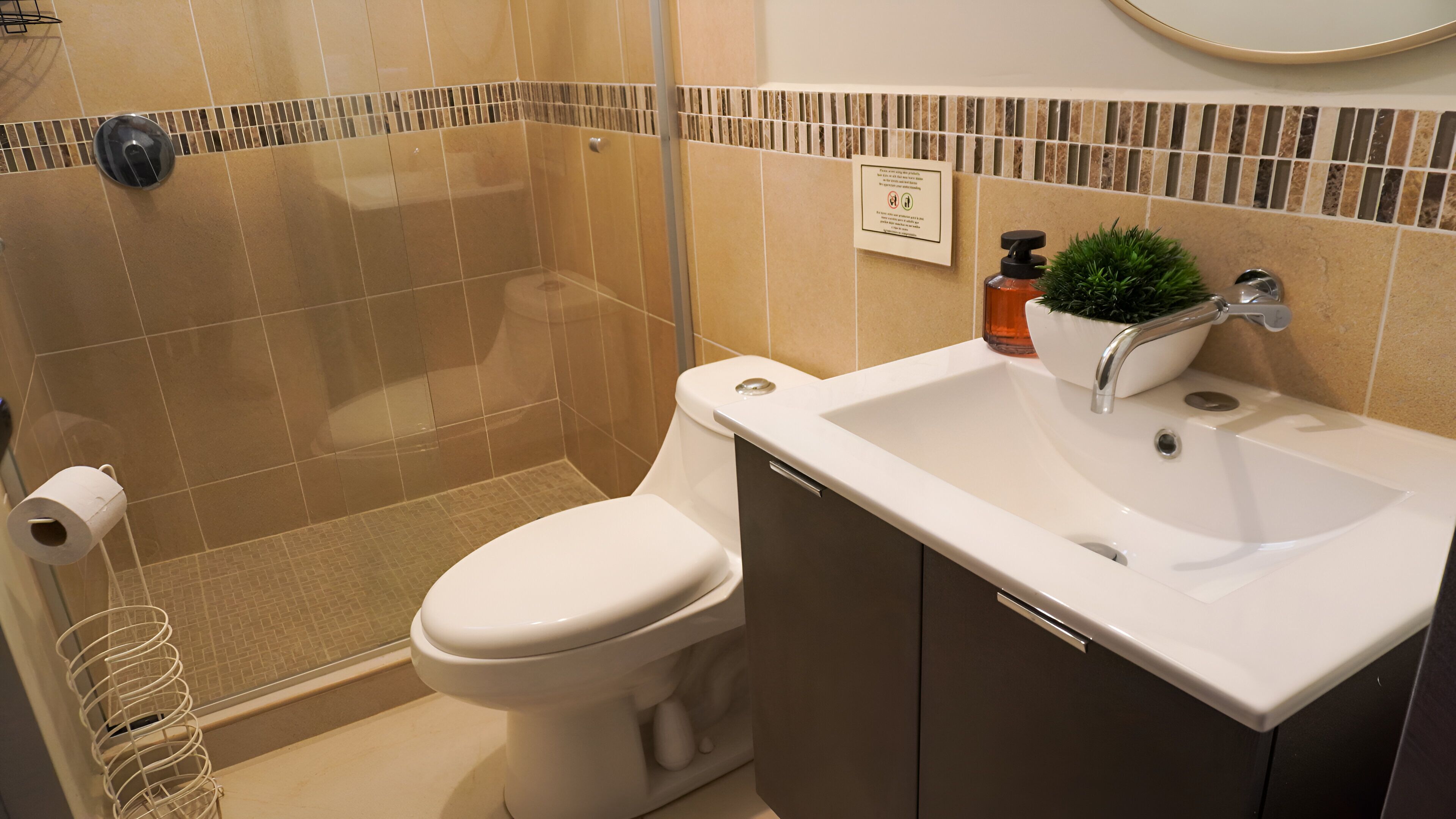 Un baño con inodoro, lavamanos y ducha.