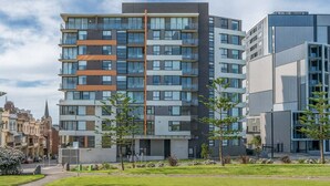 Un immeuble résidentiel à plusieurs étages, doté de balcons, d’un toit plat et d’une architecture moderne.