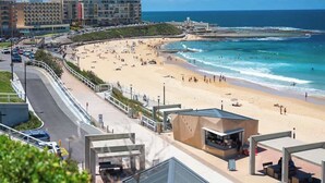 Un hôtel situé en bord de mer, avec une route sinueuse, une plage et une vue sur l’océan.