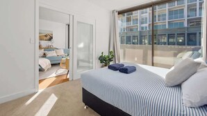 Une chambre à coucher avec un lit, une fenêtre et une vue sur un immeuble.