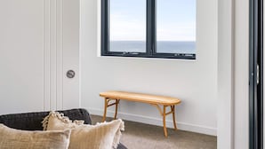 A room with a large window, a wooden bench, and a door.