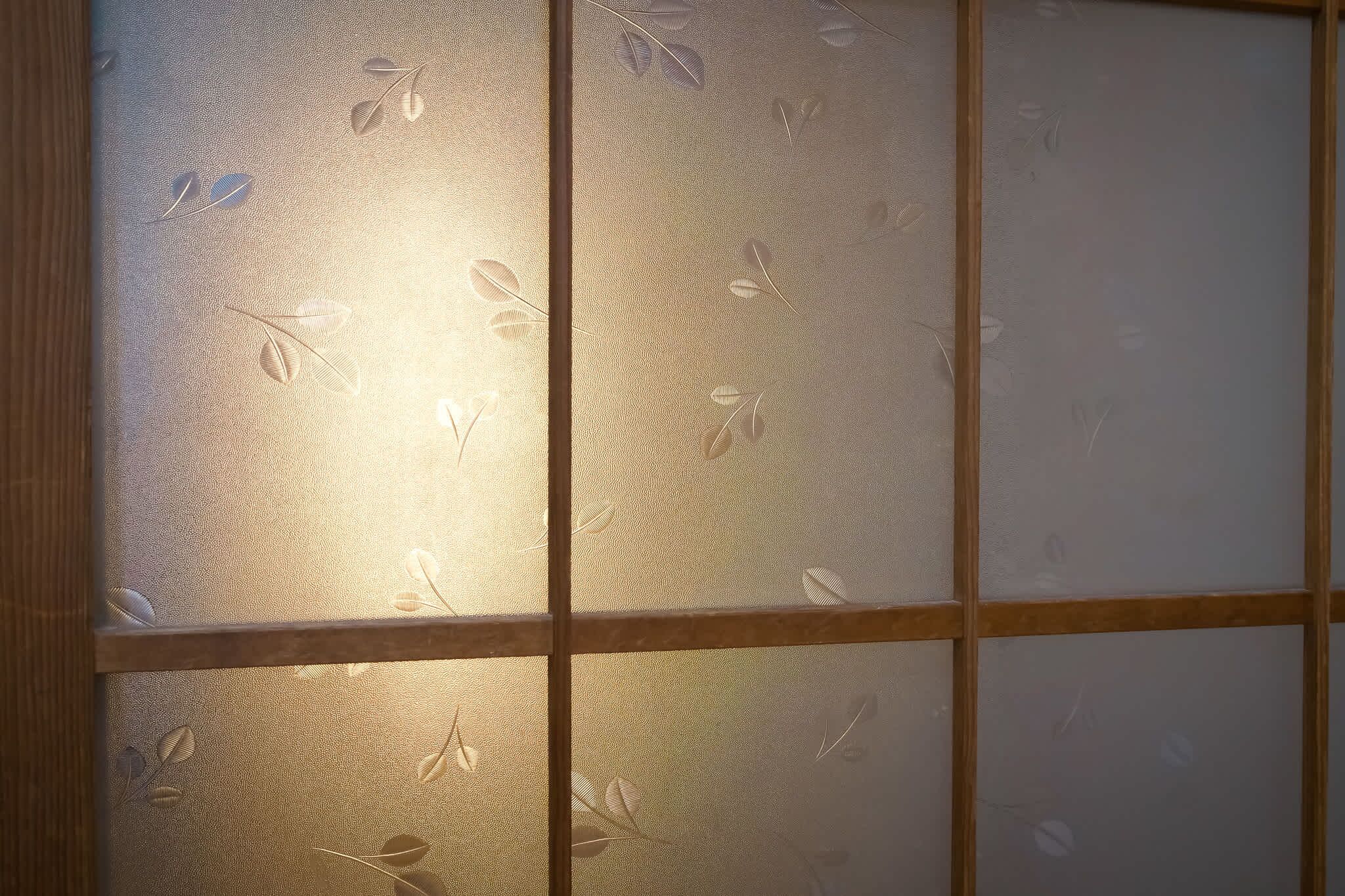 A frosted glass window with a leaf pattern.