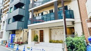 Un immeuble à plusieurs étages doté de balcons, d’une entrée sécurisée et d’une enseigne indiquant qu’il abrite une entreprise ou est utilisé à des fins commerciales.