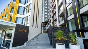 Un bâtiment moderne avec un escalier menant à l’entrée, une enseigne portant le mot « union », et deux plantes en pot.