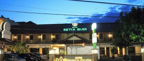 A hotel entrance with a sign reading "Setia Budi" and a logo above it.