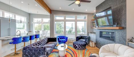 A modern kitchen with a bar area, a large window, and a ceiling fan.