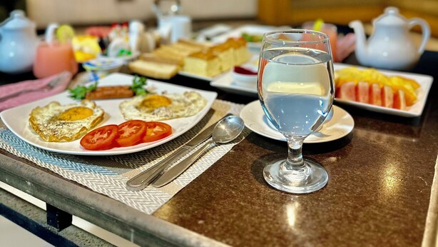 A dining table with plates of food, a glass of water, and a teapot. - Hmc Leisure Villa Dewundara (matara)
