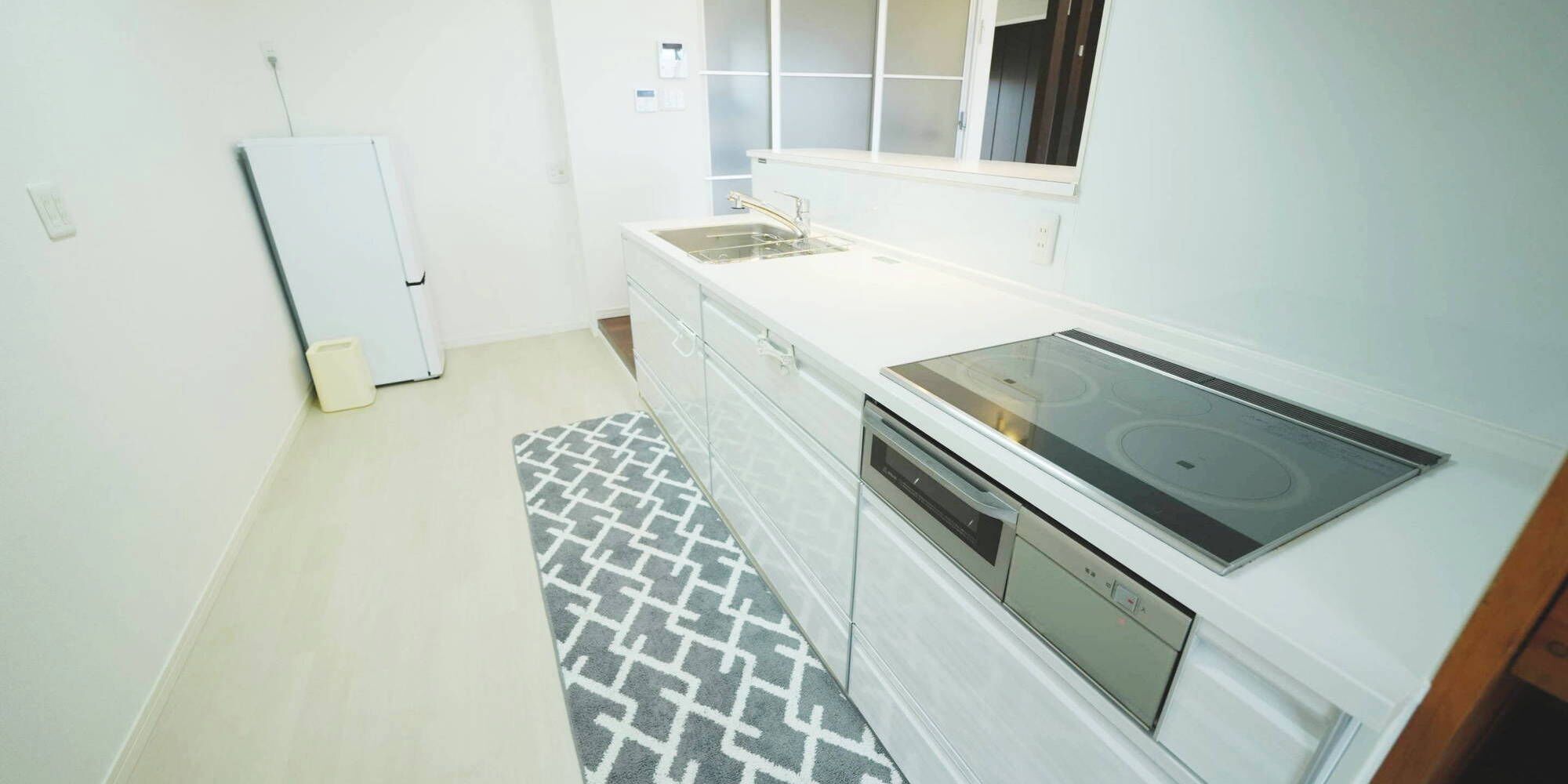 Cozinha compacta com fogão embutido, pia e geladeira.