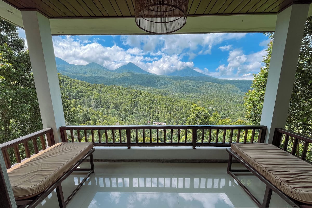Un balcon fermé offrant une vue sur un paysage montagneux.