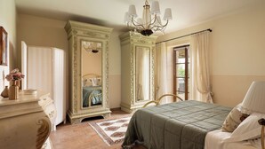 Een slaapkamer met een bed, een kaptafel, een spiegel en een kroonluchter.