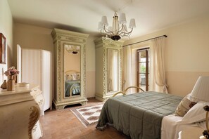 Un dormitorio con cama, cómoda, espejo y candelabro.