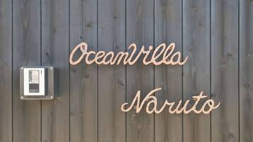 A wooden wall with the words "Oceanvilla Naruto" written in cursive.