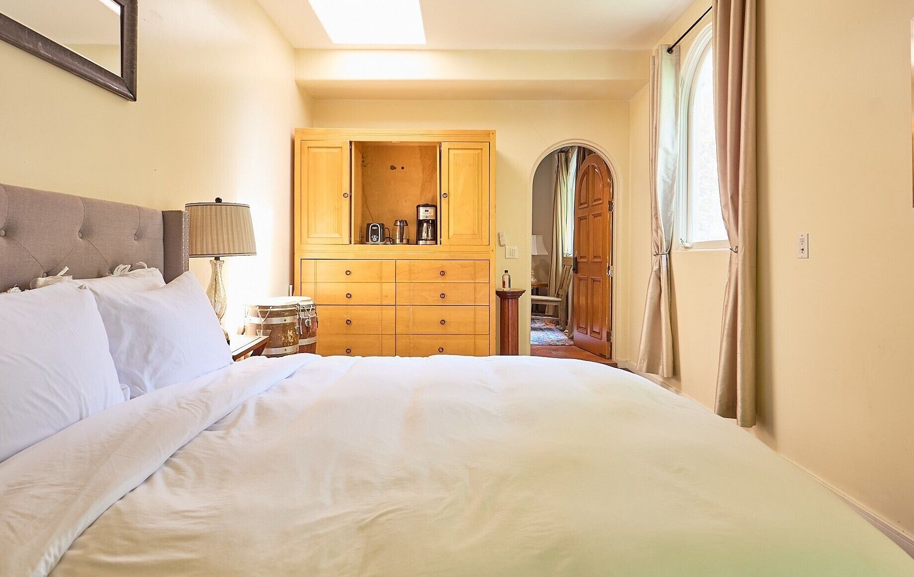 Un dormitorio con una cama grande, un armario de madera y una mesita de noche con lámpara.