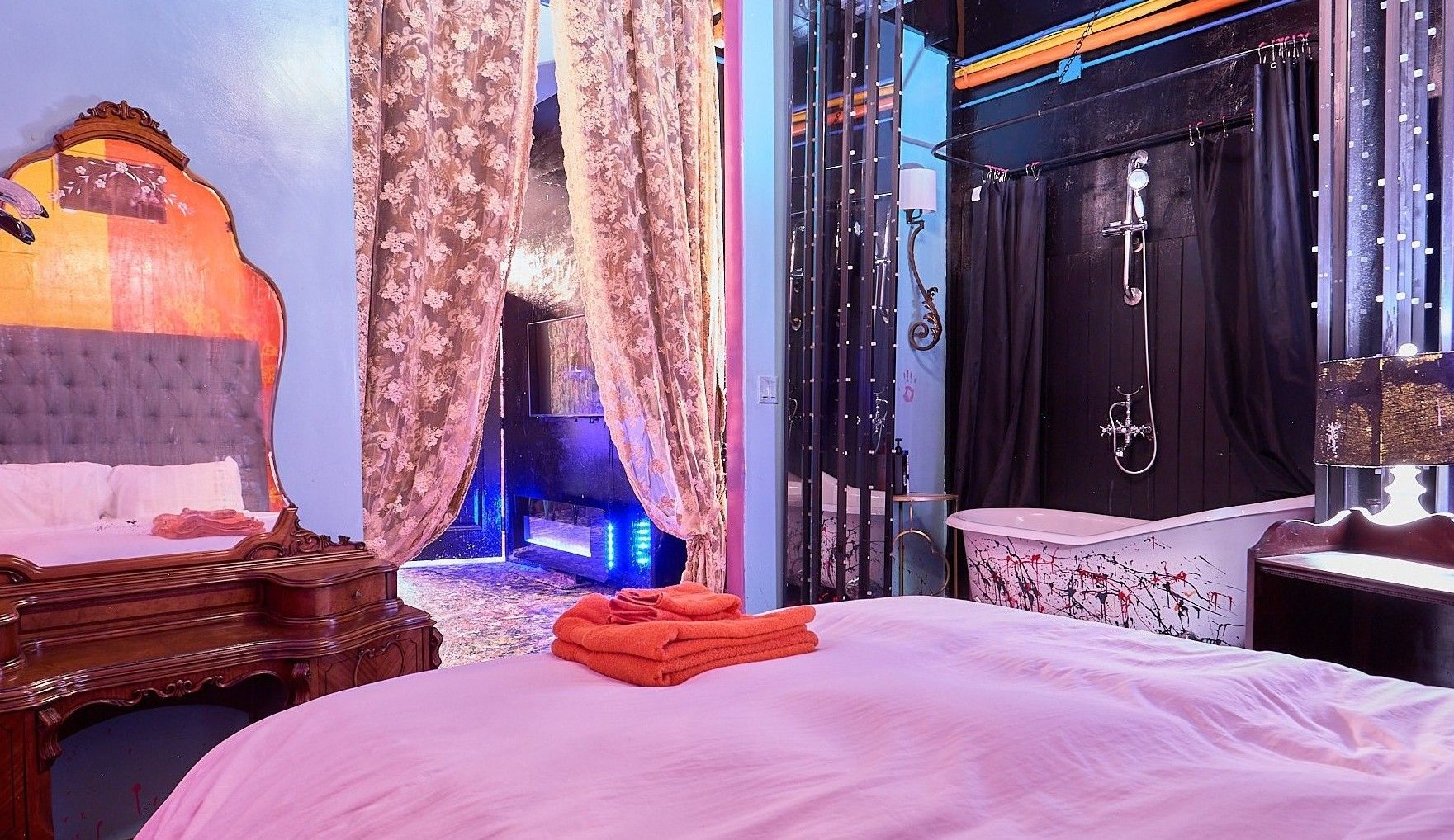 Een slaapkamer met een bed, een kaptafel en een douchehoek.