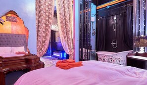 Un dormitorio con cama, tocador y zona de ducha.