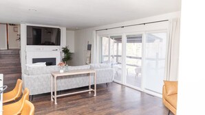 A modern living room with a grey sofa, wooden coffee table, and yellow chairs. - Rustic Lake Nokomis Cabin with Hot Tub, Trails, and Family Fun for 10! (Tomahawk)