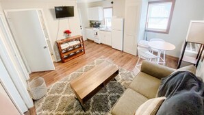 A compact living space with a kitchenette, a dining area, and a seating area with a sofa and coffee table. - Rustic Lake Nokomis 2BD/1Bath Lakeside Cabin - Cabin #3 (Tomahawk)