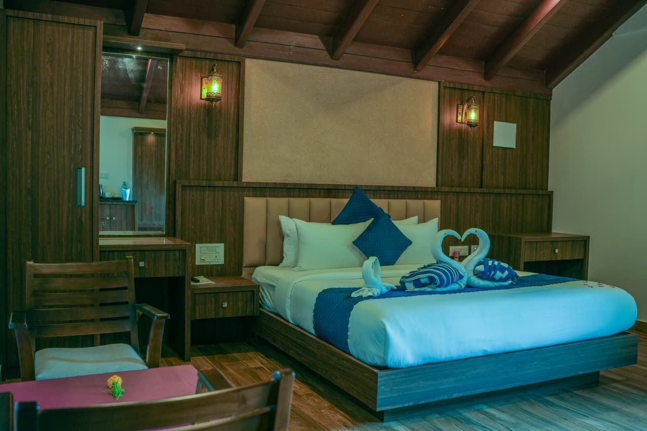 A hotel room with a wooden bed, a desk, and a chair.